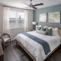 spacious bedroom with a blue accent wall and a window