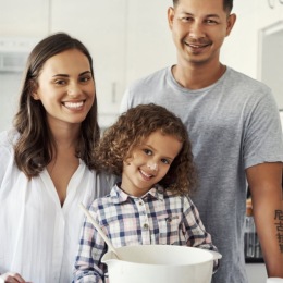 a family in a kitchen with white walls